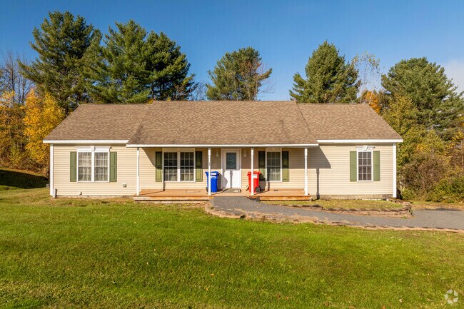 A ranch style home in Websterville has a small front porch with a gravel pathway to the door.