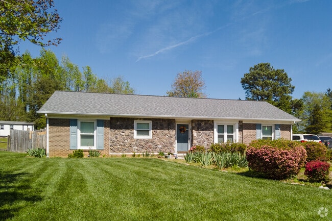 A side-gabled ranch home is showcased by a well-manicured lawn in Oak View.