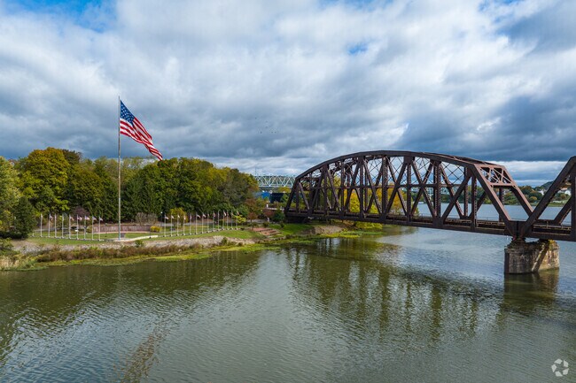 As assortment of American flags sits in Rochester Riverfront Park along the Beaver River.