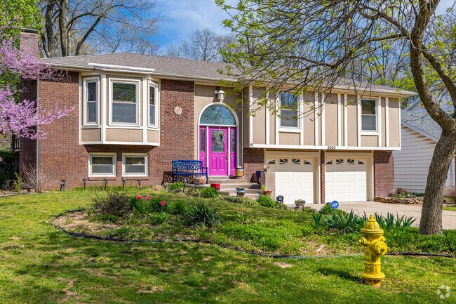 A Contemporary design 2-story home with a brightly painted front Door.