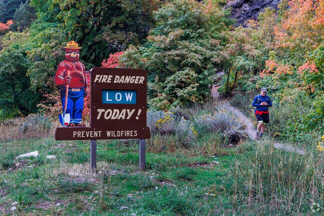 A hiker walks by a Smokey the Bear fire danger sign the Trailhead to Coldwater Springs Canyon.