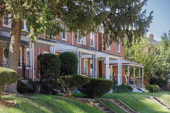 Several traditional brick Baltimore rowhomes with covered porches in Hunting Ridge.