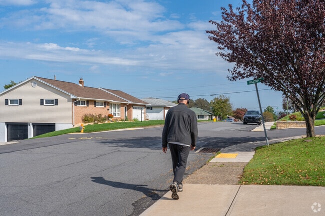 Residents get out for a walk in the neighborhood of Hughestown.