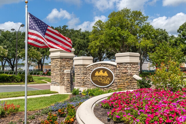 Colorful blooms and a proud flag welcome you home at the entrance to Lexington Oaks.