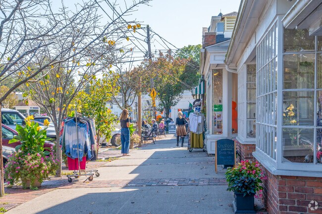 Charming town of Guilford as pedestrians stroll past boutique storefronts.