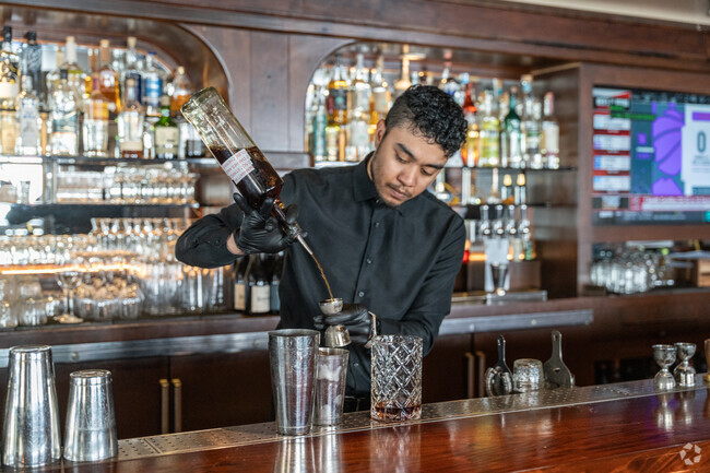 A bartender at Gravity nearby Blithedale pours an old fashioned style Manhatten.
