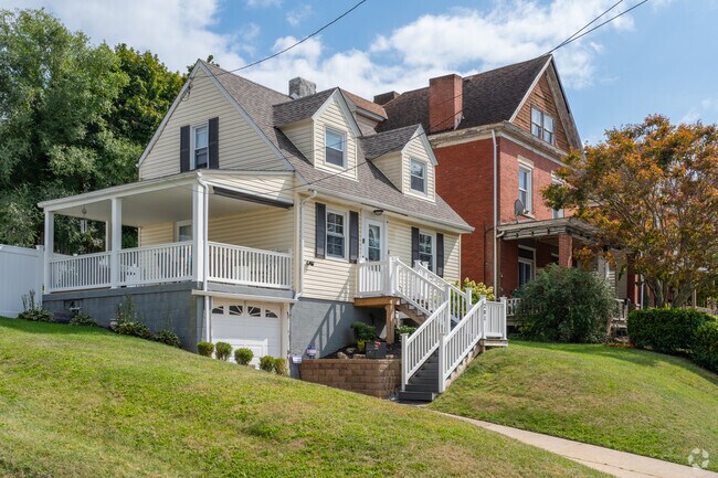This Cape Cod in Bon Air sits perched on a hill with a side deck and lower level garage.