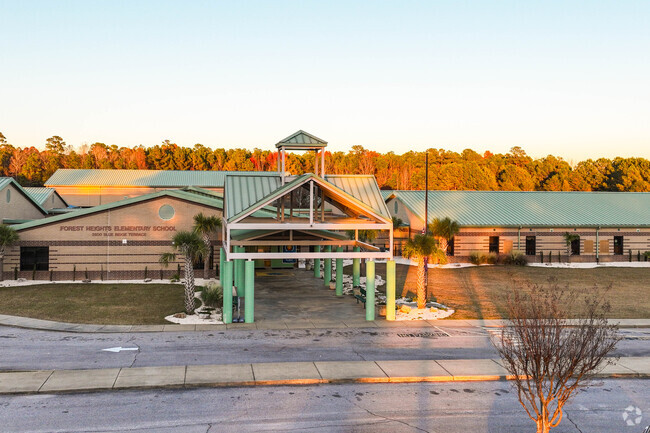 Students enter the Forest Heights Elementary School in Columbia in a shaded portico.