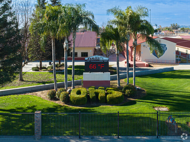 A beautiful marquee at Orosi High School is surrounded by palm trees.