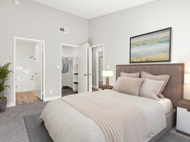 Carpeted bedroom with private bathroom.