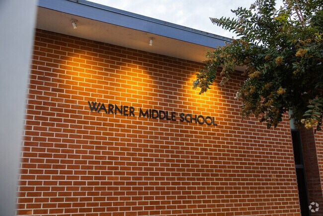 Warner Middle School's insignia shines during both day and night time.