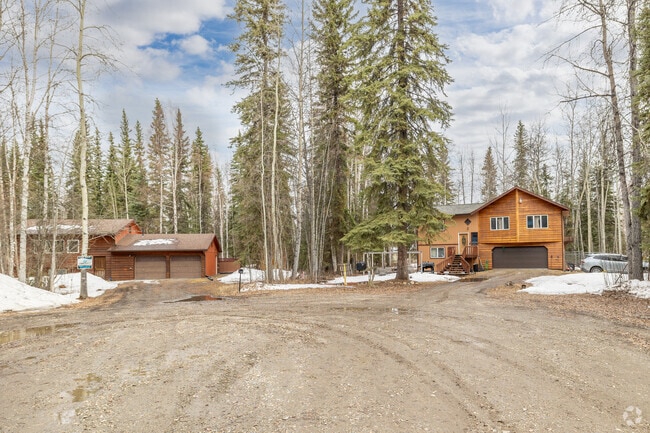 Wood cabins and tall pines frame a cozy neighborhood road in Badger, Fairbanks.