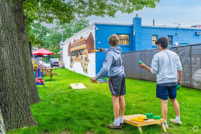 Friends enjoy playing cornhole outside of Nabs 1 Stop country store near West Chelmsford.