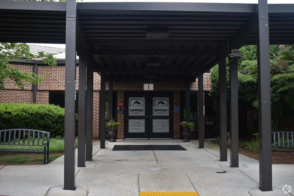 Main entrance to Dolvin Elementary School in Johns Creek, Alpharetta GA has a bench for sitting.