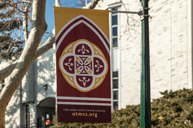 A colorful banner hangs from a streetlamp at The Madeleine Choir School.