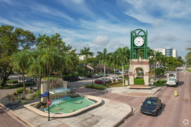 There is a clock tower and fountain outside of South Miami City Hall.
