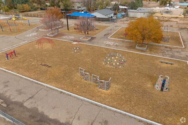 The metal climbing gym and wood-chipped play area at Cochiti Middle School.