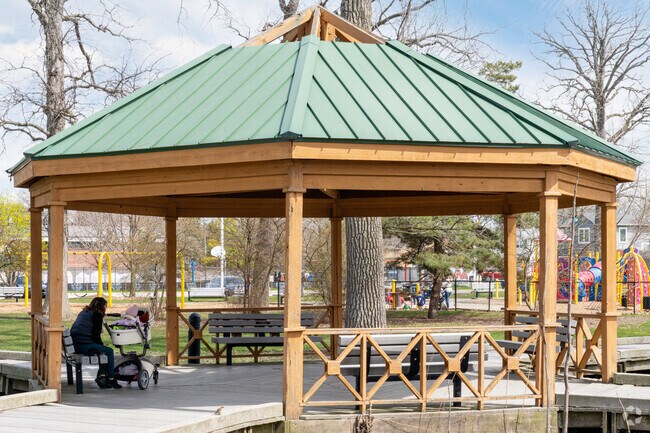 A mom and her baby enjoy the shade under the gazebo in Devonshire Park.