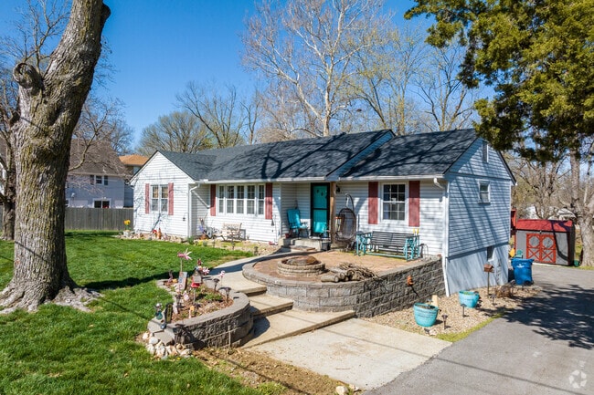 A charming bungalow-style home in Maple Park, featuring a welcoming front patio, colorful accents, and a landscaped yard that adds plenty of personality.