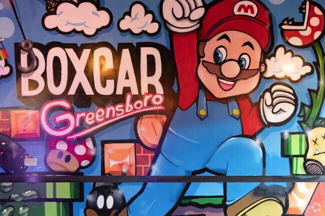 Admiring Benjamin Benson's art mural at Boxcar Bar + Arcade.