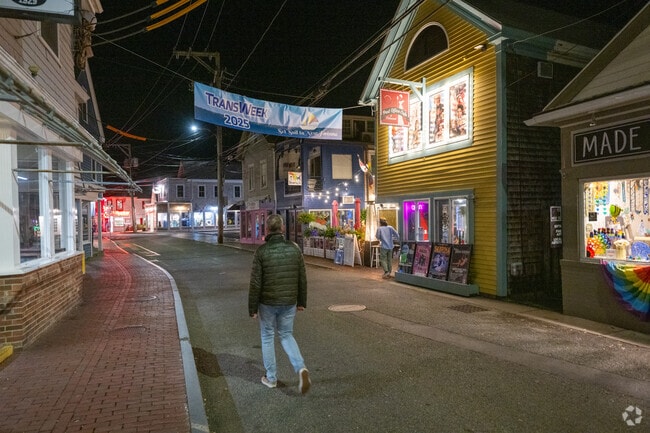 Provincetown streets buzz with pedestrians under glowing shop signs.