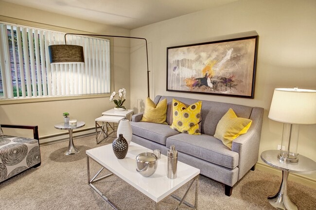 A living room with couch, coffee table, and sliding windows