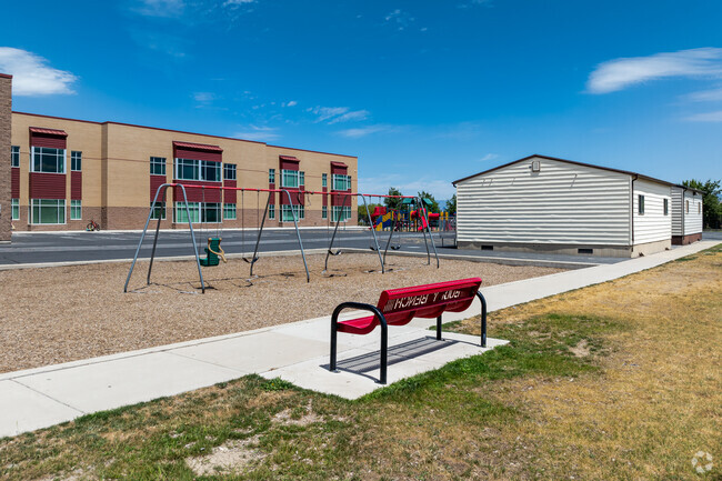 A red bench faces the swings at Eastlake Elementary School.