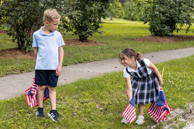 The children of Glendale are gathering up flags after a Memorial Day Parade.