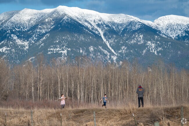 Children bring collected sticks back from the Flathead River in Evergreen for their father to load in their truck.
