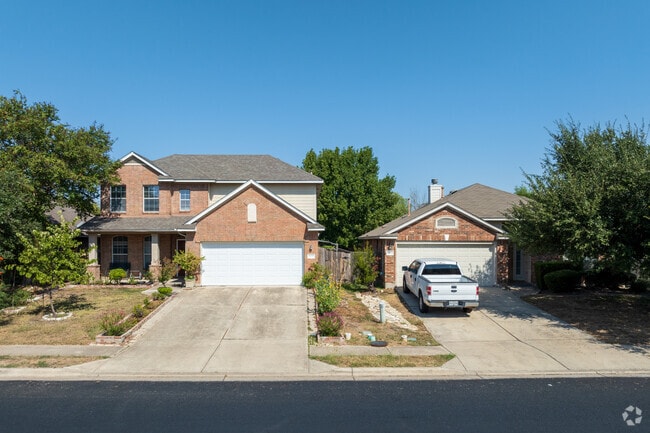 A two-story home on Parmer Lane with a garage and charming stone accents.