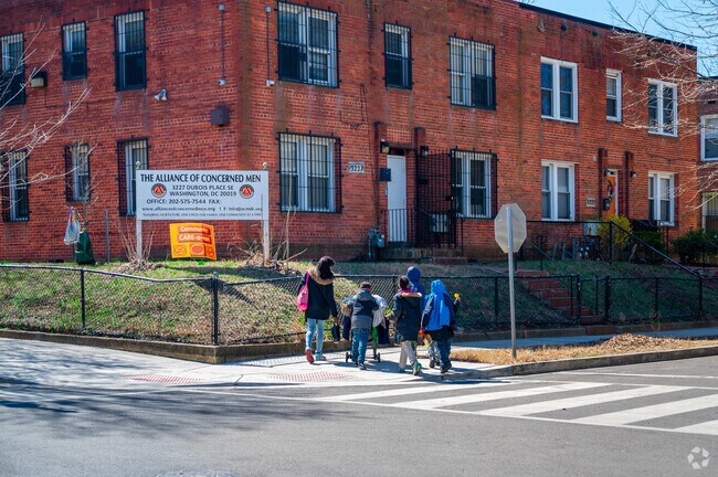 A mother and her children crossing the street in the Greenway neighborhood.