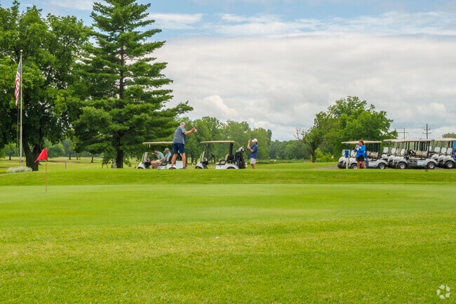 A golfer tees off under cloudy skies at the Pryor Creek golf course on a quiet afternoon.