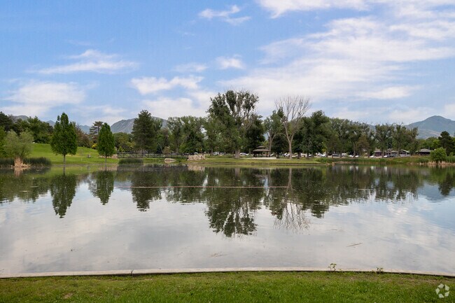 A large pond with reflections of mature trees at Liberty Park.