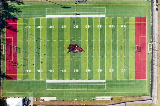 An aerial view of the athletic field at Conant Middle High School near Rindge, featuring the school’s Orioles logo at midfield.