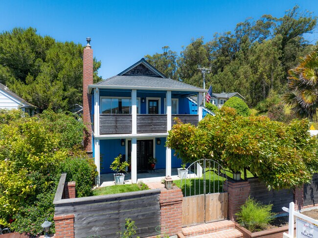 Blue two-story home with white columns and upper patio reflects coastal charm in Davenport.