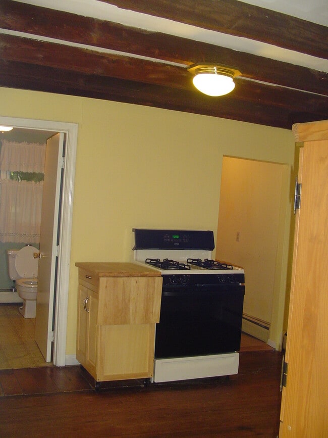 Kitchen stove, bathroom on left, laundry room on right