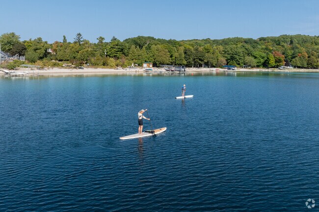 Paddle-boarders enjoy the scenic views of Omena Bay.