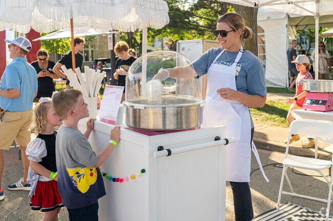 Kids eagerly await their cotton candy at the Gathering On The Green festival in Western Springs.