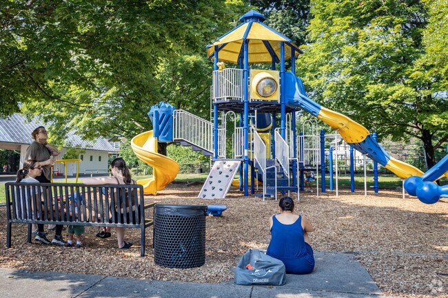 Parents enjoy each others company while their kids play on the playground in Rose Hill.