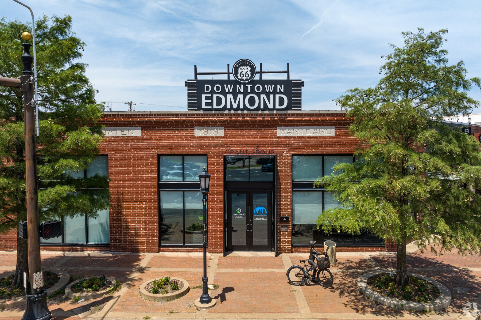 The main entrance to Downtown Edmond is marked by Route 66 signage and the paperboy sculpture.