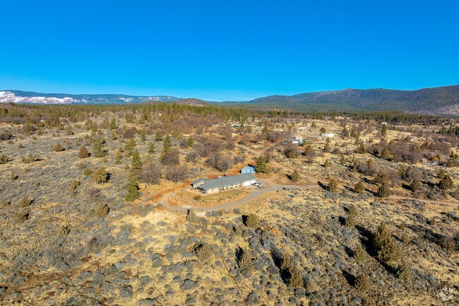 A ranch-style home is comfortably nestled atop a hill with beautiful views of the surrounding outdoors.