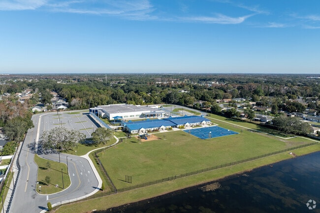 Pinar Elementary School's scenic entrance features a large grass field and a man-made lake.