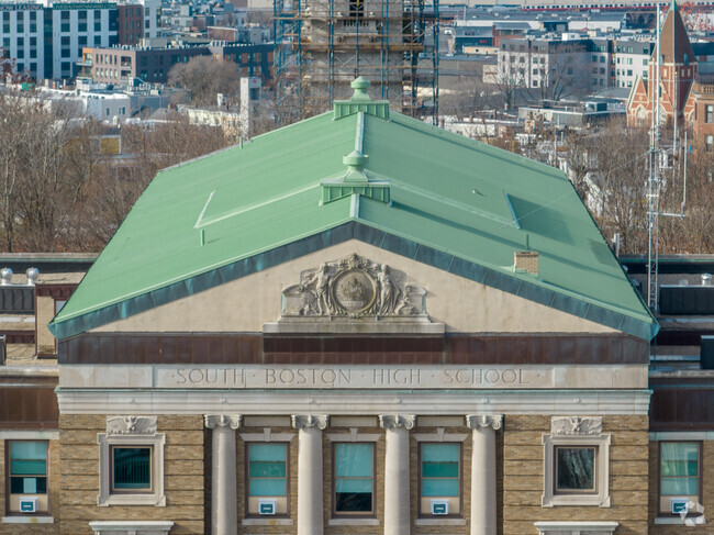 An ornate sculpture adorns the top of Excel High School in Boston.