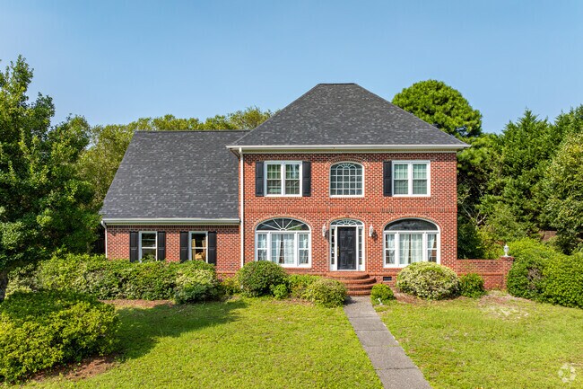 A French-style New Traditional home is nestled under mature trees in Pine Valley.
