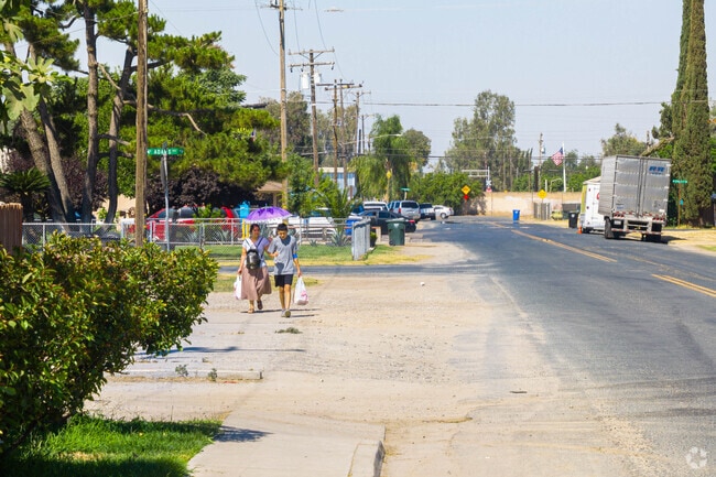 Two Tipton residents walk along Adams Road after shopping at local businesses.
