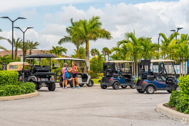 Verano residents enjoying a chat after their pickle ball match at golf cart parking lot.