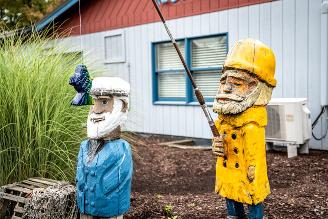Wooden fisherman sculptures can be seen in Pine Brook.