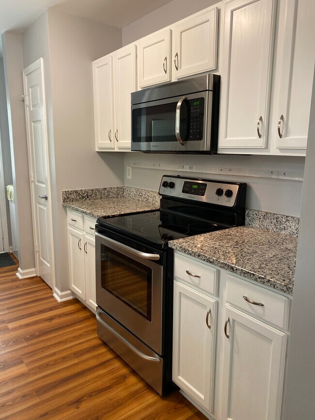 Another kitchen view showcasing the cabinets, granite counter and storage space with pantry