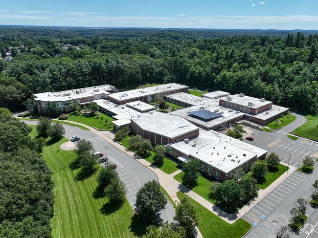 Amesbury High School in Amesbury is surrounded by densely packed trees and green lawns.