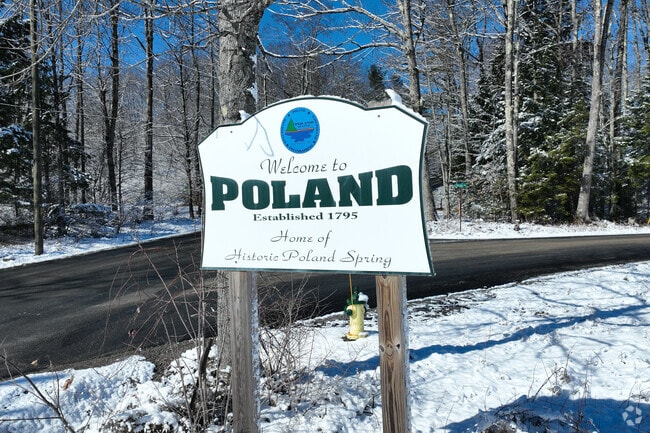 Winding roads in Poland, Maine, unveil picturesque vistas of rolling fields.